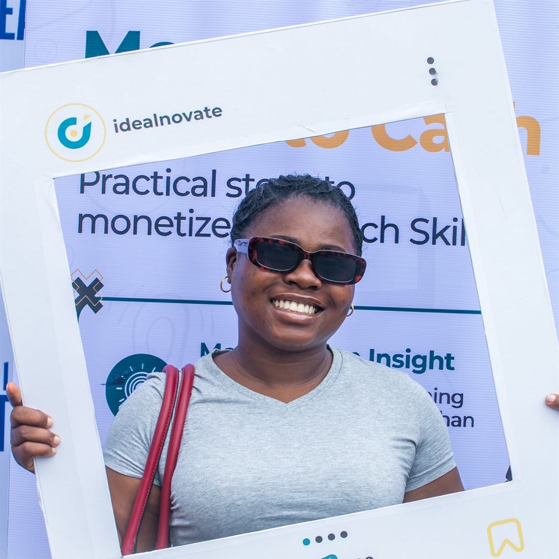 A smiling attendee poses with an Idealnovate photo frame