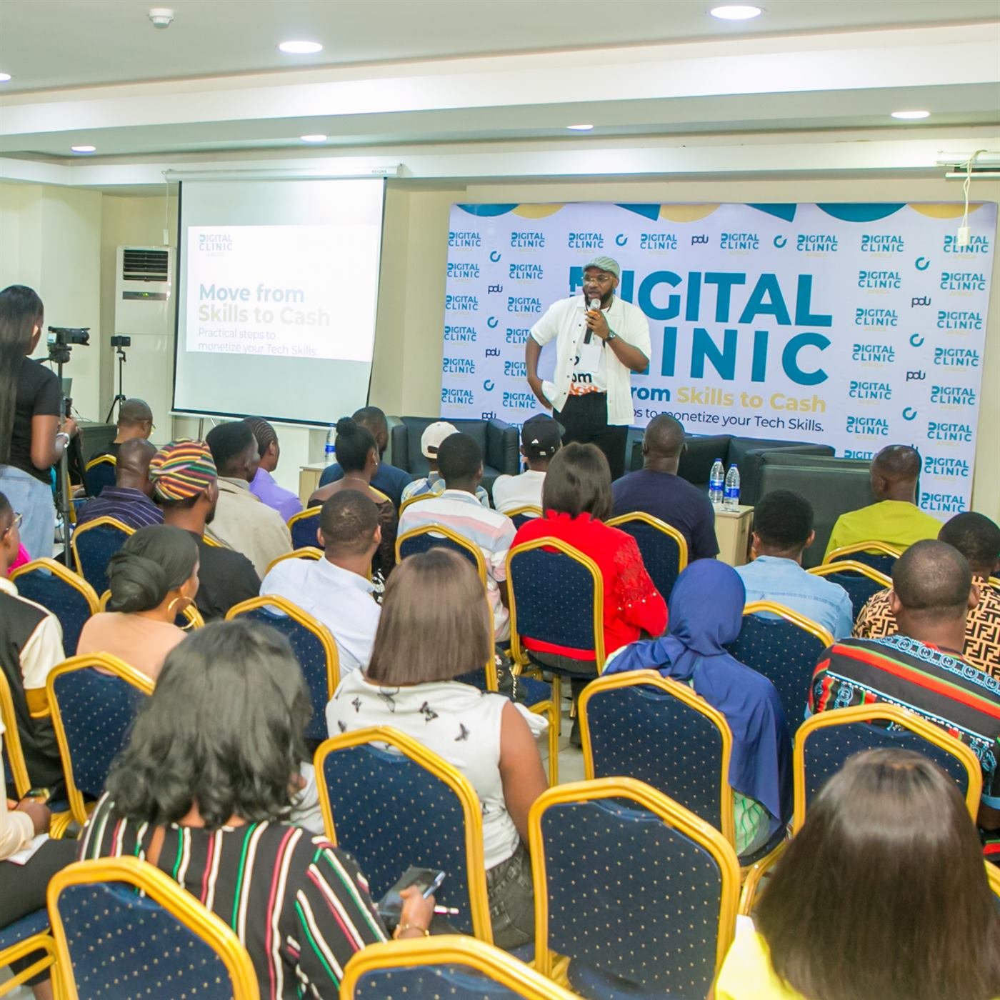 A speaker addresses a full room at the last Digital Clinic